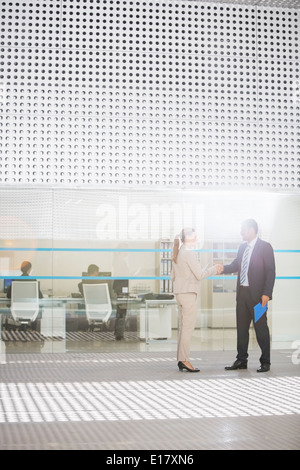 Imprenditore e imprenditrice di handshaking ufficio esterno Foto Stock
