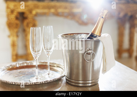 Champagne in argento secchio accanto a champagne flauti Foto Stock