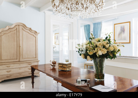 Lampadario su bouquet di rose sul tavolo nel foyer di lusso Foto Stock