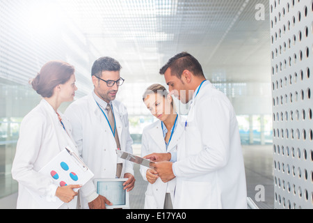 Medici con appunti parlando in ospedale corridoio Foto Stock