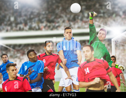 I giocatori di calcio di saltare sul campo Foto Stock