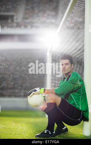 Goalie tenendo palla calcio by Net Foto Stock