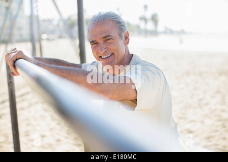 Ritratto di senior uomo appoggiato su bar in spiaggia Foto Stock