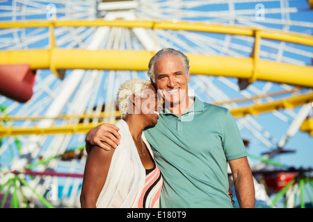 Ritratto di abbracciando coppia senior presso il parco di divertimenti Foto Stock