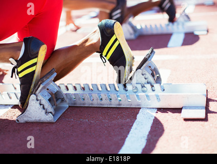 Runner i piedi in blocchi di partenza sulla via Foto Stock