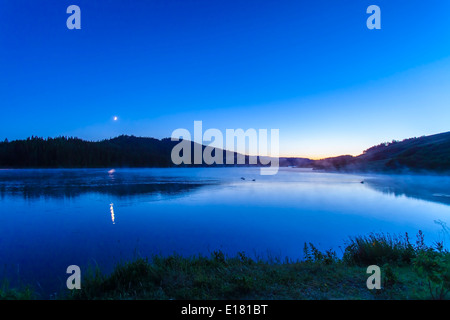 La luna crescente impostazione Reesor sopra il lago di Cypress Hills parco interprovinciale, sul lato di Alberta. Foto Stock