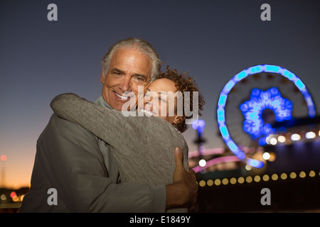 Ritratto di giovane costeggiata al di fuori del parco di divertimenti di notte Foto Stock