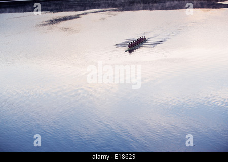 Equipaggio di canottaggio scull canottaggio sul lago in distanza Foto Stock