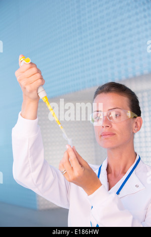 Scienziato usando una pipetta e provetta di test in laboratorio Foto Stock