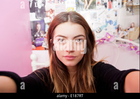 13 adolescenti anno vecchia ragazza in posa per una finta selfie nella sua camera da letto Foto Stock