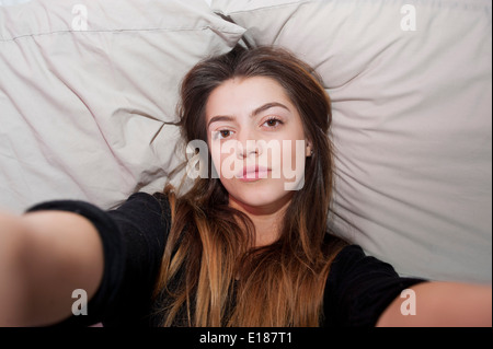 13 adolescenti anno vecchia ragazza in posa per una finta selfie nella sua camera da letto Foto Stock