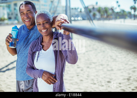 Ritratto di sorridente coppia senior sulla spiaggia parco giochi Foto Stock