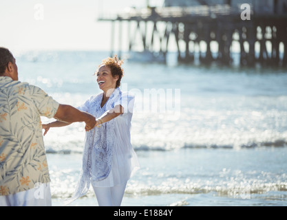 Entusiasta coppia danzante di sunny beach Foto Stock