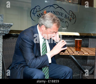 Nigel Farage su telefono gode di Vittoria pinta al di fuori delle piume Pub pub Nicholson Broadway Street a Londra. Egli andò con il UKIP Team per festeggiare MEP vittoria elettorale Maggio 2014 Credit: Prixnews/Alamy Live News Foto Stock