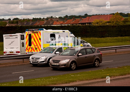 NHS scozzese servizio ambulanza macchine passando lungo la strada a doppia carreggiata di rispondere ad un 999 chiamata di emergenza nelle aree urbane Dundee, Regno Unito Foto Stock