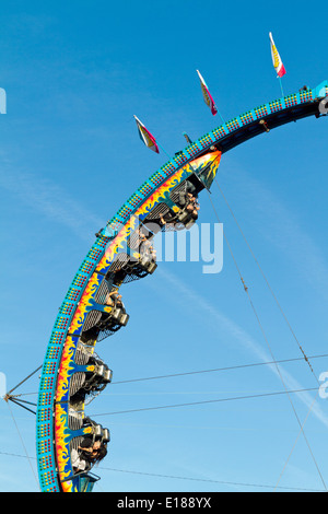 Entusiasti piloti appeso a testa in giù su un carnevale ride facendo un loop. Foto Stock