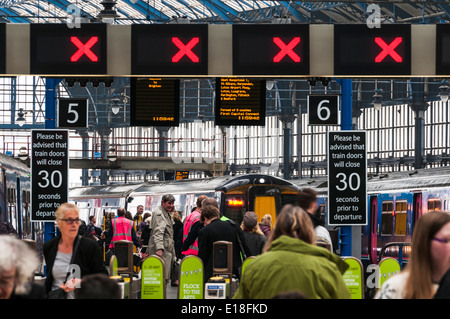 I treni First Capital Connect si trovano in un atrio pieno di passeggeri alla stazione ferroviaria di Brighton Foto Stock