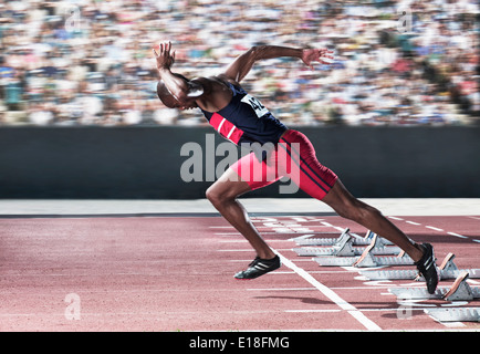 Sprinter tenendo fuori dal blocco di partenza sulla via Foto Stock
