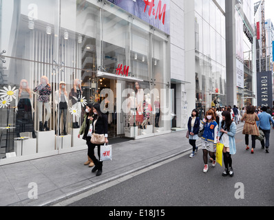 I giovani a camminare su strade in uno dei Tokyo quartieri della moda. HM e sempre 21 abbigliamento moda nei negozi di Tokyo Foto Stock