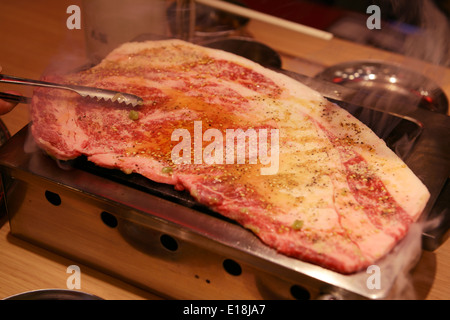 Le carni bovine sono cotti su una griglia stufa a un giapponese ristorante grill. Yakiniku, Giapponese barbecue. Foto Stock