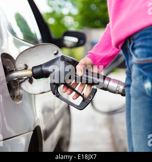 Lady di pompaggio del carburante benzina in auto alla stazione di gas. Foto Stock