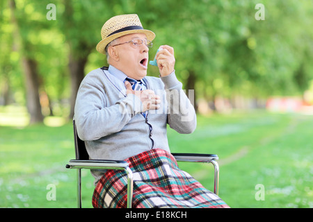 Senior a parzializzazione di uomo nel parco e la tenuta di un inalatore Foto Stock