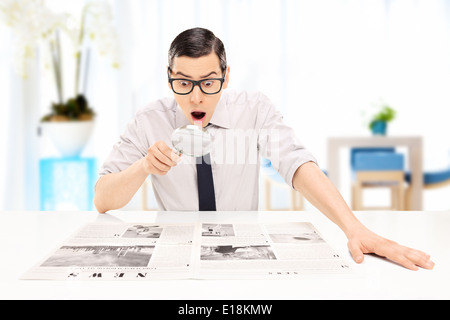 L uomo ha sorpreso la lettura di notizie con controllo in un ufficio Foto Stock