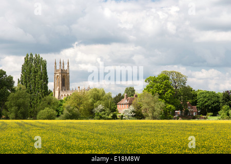 Guardando attraverso prati fioriti verso San Pietro ad Vincula chiesa parrocchiale a Hampton Lucy, Warwickshire, Inghilterra, Regno Unito Foto Stock