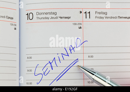 Ein Termin ist in einem Kalender eingetragen: seminario Foto Stock