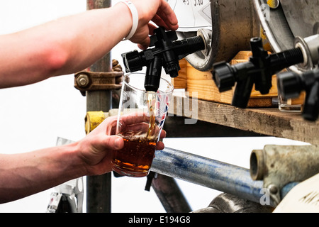 Una pinta di real ale che viene versato dal barile. Foto Stock