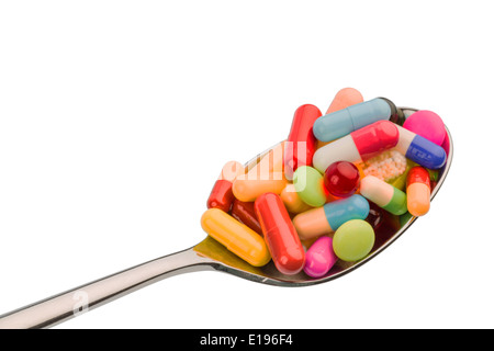 Viele bunte Tabletten auf einem Lˆffel. Symbolfoto f'r Tablettensucht und Miflbrauch von Medikamenten. Foto Stock