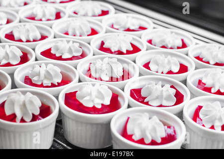 Gelatina di rosso con panna montata in tazza bianca Foto Stock