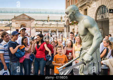 Mimo Duncan prati come un gigante verde statua umana di eseguire per i turisti al Covent Garden di Londra, Inghilterra, Regno Unito Foto Stock