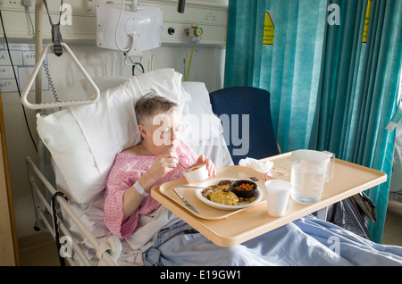 Paziente anziano in University College Hospital di mangiare cibo da ospedale, London, England, Regno Unito Foto Stock