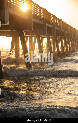 Il bagliore dorato della mattina presto sole risplende attraverso la Spiaggia di Jacksonville Pier nel nord-ovest della Florida, Stati Uniti d'America. Foto Stock