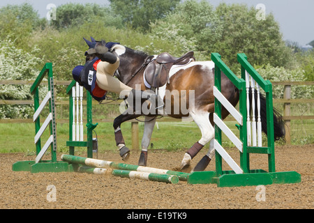 Uno di una serie di foto che mostra un cavaliere di essere sbalzati fuori dal suo cavallo in un recinto durante un show jumping concorrenza Foto Stock