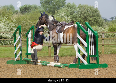 Uno di una serie di foto che mostra un cavaliere di essere sbalzati fuori dal suo cavallo in un recinto durante un show jumping concorrenza Foto Stock