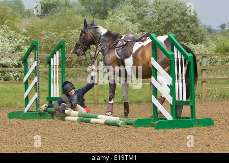 Uno di una serie di foto che mostra un cavaliere di essere sbalzati fuori dal suo cavallo in un recinto durante un show jumping concorrenza Foto Stock