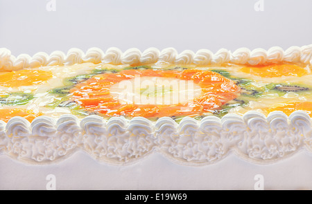 Fruttato torta decorata con mosaico di frutta sulla sommità di arance e kiwi. Foto Stock