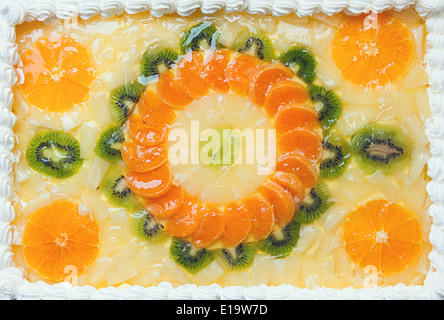 Fruttato torta decorata con mosaico di frutta sulla sommità di arance e kiwi. Foto Stock