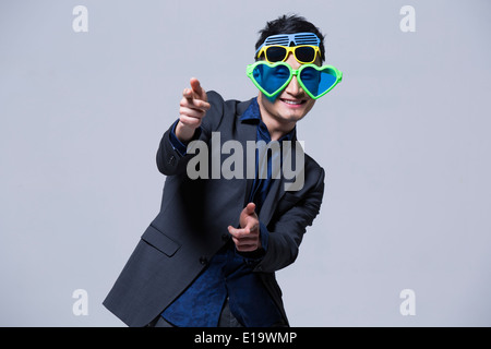 Hip giovane uomo che indossa più paia di occhiali da sole Foto Stock