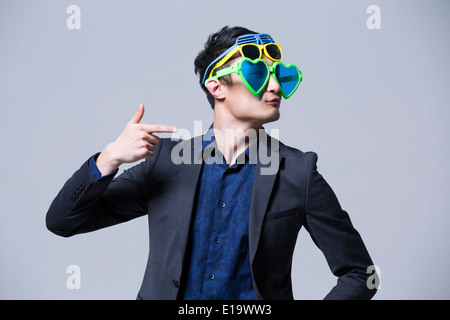 Hip giovane uomo che indossa più paia di occhiali da sole Foto Stock