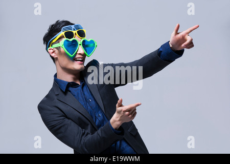 Hip giovane uomo che indossa più paia di occhiali da sole Foto Stock