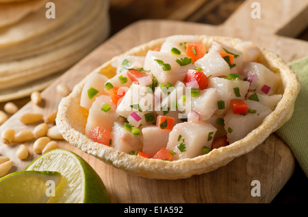 Un preparata di fresco pesce bianco ceviche con pomodoro, cipolla rossa, il coriandolo, pepe rosso, calce e serrano il pepe. Foto Stock