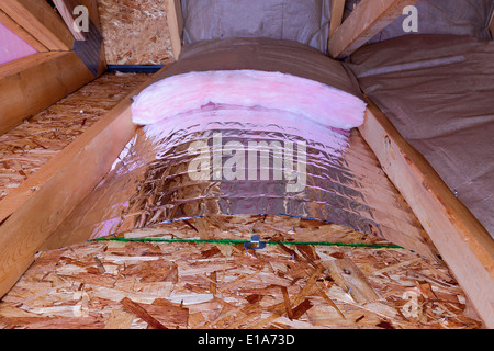 Isolamento del sottotetto con vetroresina barriera fredda e Barriera termica riflettente utilizzato come divisorio tra la soffitta travetti, lavoro Foto Stock