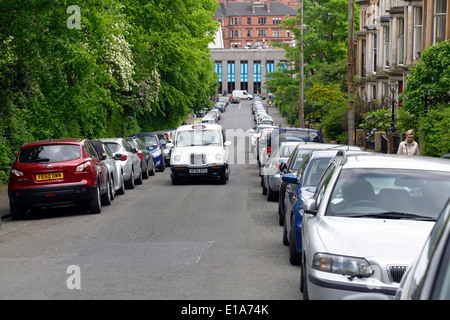 Glasgow West End, vista lungo Huntley Gardens occupato con auto parcheggiate verso Byres Road, Scozia, Regno Unito Foto Stock