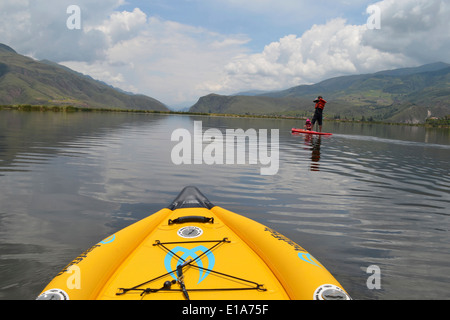 Un uomo Stand Up Paddle Boarding (SUP) con i suoi figli sulla Laguna Huacarapay, nel vicino a Cusco, Perù Foto Stock