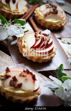 Tortine con fette di mela, crema e riempimento alle noci pecan Foto Stock