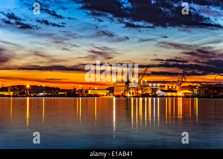 Tramonto su un settore del porto con gru a Stavanger, Norvegia. Foto Stock