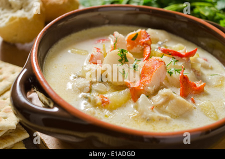 Una fumante tazza di zuppa di pesce con aragosta, vongole, eglefino, capesante e patate. Foto Stock